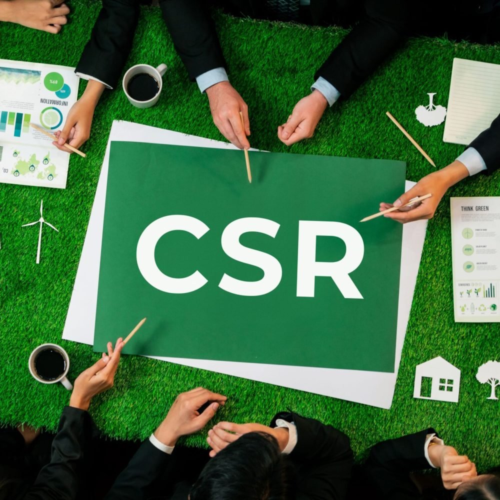 Top view panoramic CSR symbol on green grass table with business people planning for alternative energy utilization for greener sustainable Earth as corporate social responsibility. Quaint